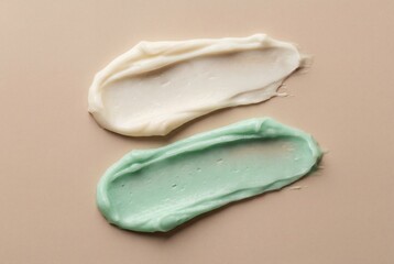 Texture of white and green cosmetic clay mask smears isolated on a solid beige surface