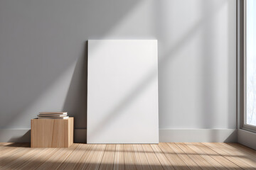 Fototapeta premium Blank canvas leaning against wall with books on wooden box in bright room