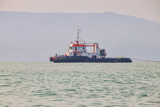 Palabuan Ratu - Sukabumi, West Java, Indonesia - December 21, 2021. Workboat cruising offshore with mountains in distance