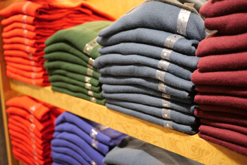 Sweaters stacked neatly on shelves in a store display