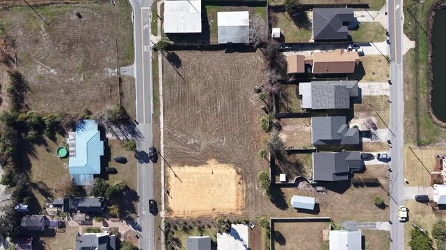 Top-down upward drone fly of a residential house empty construction lot and surrounding area, Panama City, Florida, USA