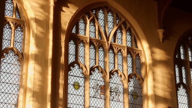 Sunlit Glass Window With Arched Frame Inside St. Mary's Church In Saffron Walden, UK. closeup shot