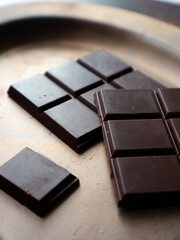 Dark chocolate pieces on plate, minimal dessert concept