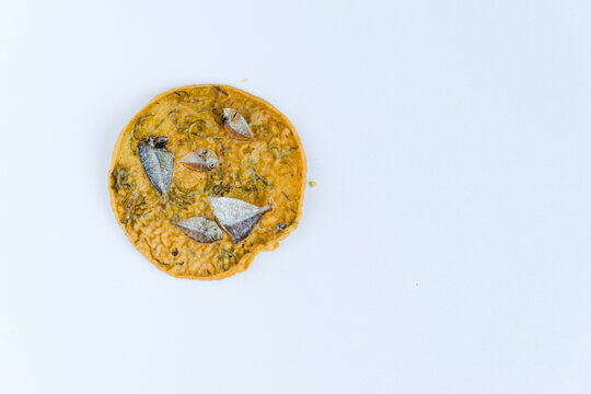 A savory crackers called "Rakik Maco," a traditional snack from Pariaman, West Sumatra. Made from rice and wheat flour, are topped with crispy dried anchovies, perfect for food and travel themes.