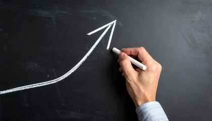 Hand drawing an upward arrow on a chalkboard, symbolizing business growth, financial success, and positive performance trends.