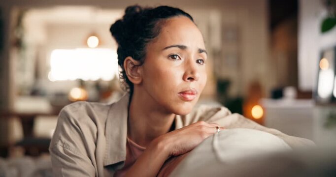 Sad, thinking and woman in home with anxiety, worry or loneliness with broken heart in living room. Lost in thoughts, reflection and person with depression, stress or memory for breakup on sofa
