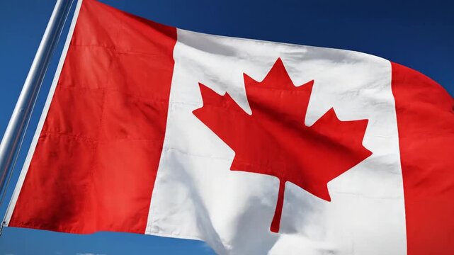 Canada's Emblem: The iconic flag of Canada proudly waves against a clear, azure sky, its striking red and white colors and the prominent maple leaf symbol representing the nation's heritage.
