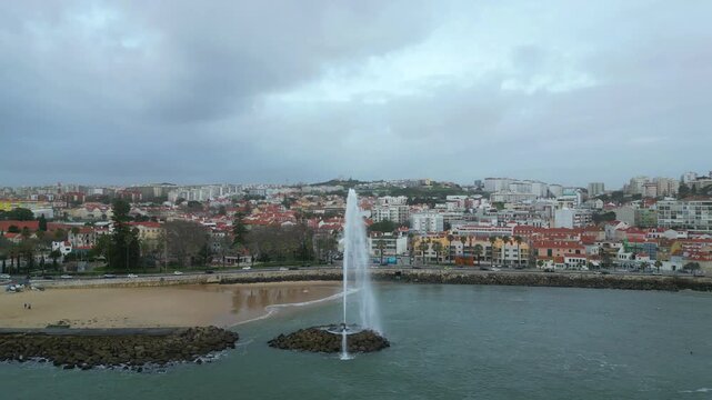 Circular view over the Marine Geyser in Pa&ccedil;o de Arcos,with the beautiful marginal and the town in the background.Oeiras,Portugal.
Circular drone shot, cloudy day