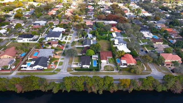 Aerial footage flying over a beautiful residential neighborhood with single family homes and pools in Florida