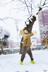 雪の公園で遊ぶ6歳の男の子