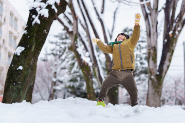 雪の公園で遊ぶ6歳の男の子