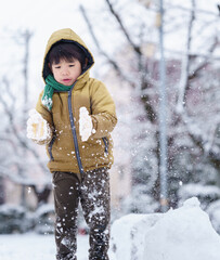 雪の公園で遊ぶ6歳の男の子