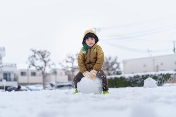 雪の公園で遊ぶ6歳の男の子