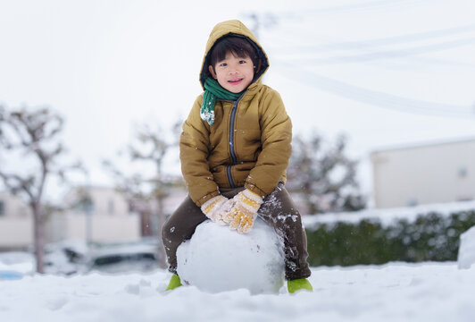 雪の公園で遊ぶ6歳の男の子