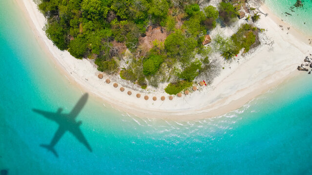 Aerial view of shadow passenger plane silhouette and sandy beach blue sea with waves at sea beach summer vacation sea travel concept	