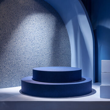 Minimal blue podium scene with geometric shapes, stone arch and soft shadow lighting