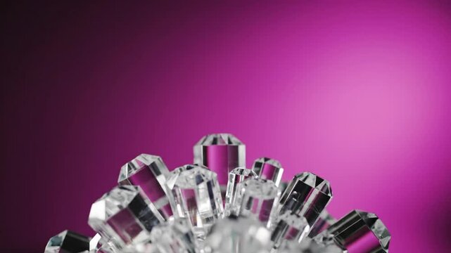 Close-up of crystal shapes in front of a radiant magenta gradient background