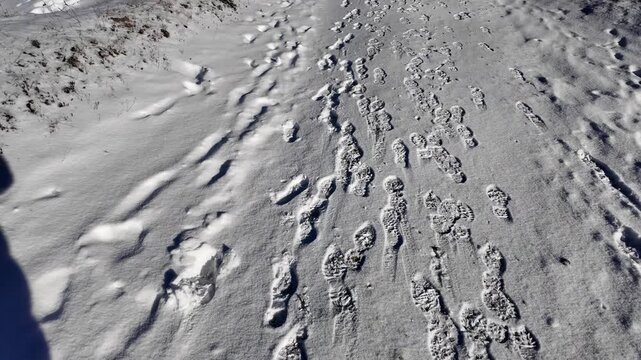 Slow motion close up of human footprints in fresh snow in mountains