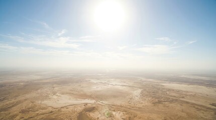 Sky with bright sun and extreme global climate concept. Stunning aerial view of a vast, arid landscape under a bright sun.