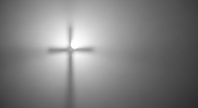Abstract, high-contrast cross silhouette glowing on a somber good friday background with copy space.
