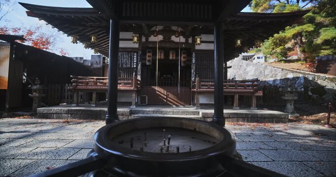 Steady cam in on ancient Japanese shrine with cauldron of incense