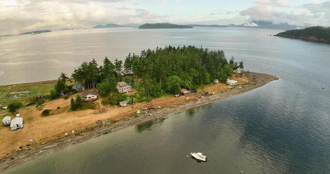 Rising Aerial Fly Away from Eliza Island with Rainbow and San Juan Islands at Sunset