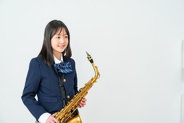 Fototapeta premium アルトサックスを持って笑顔の制服姿の日本人少女