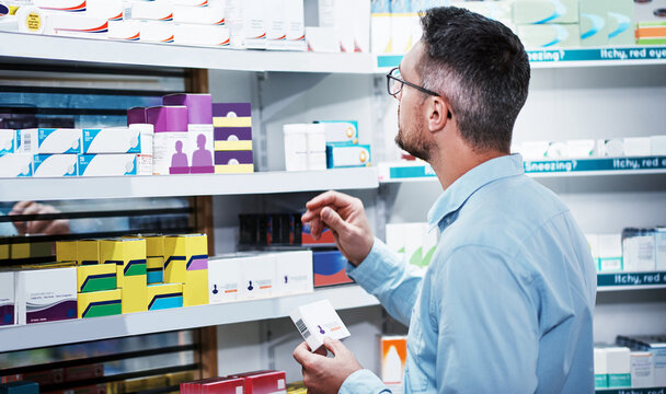 Pharmacy, shopping and man with medicine box, customer supplements or comparing drug. Retail, dispensary shop and mature person with pills for medical information, pharmaceutical or healthcare choice