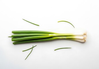 Fresh green onions bunch with scattered leaves on white surface
