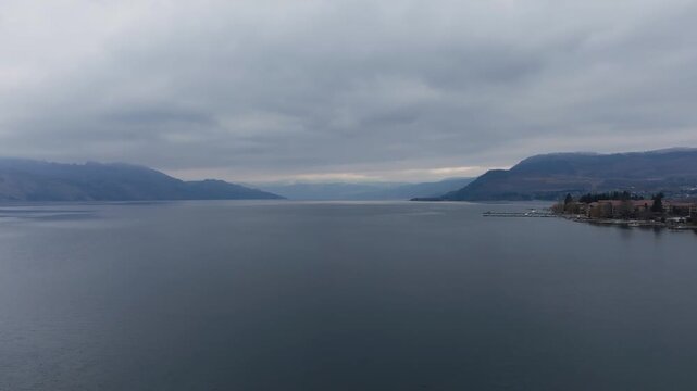 Drone flying up from a large mountain lake