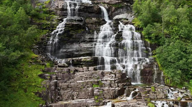 descending drone flight, water and rocks of a big waterfall in Norway. Amazing nature, water falling from mountain, plants are growing on the rocks. Pure water, pristine nature. Tvindefossen. Fresh wa