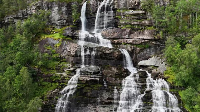descending drone flight, water and rocks of a big waterfall in Norway. Amazing nature, water falling from mountain, plants are growing on the rocks. Pure water, pristine nature. Tvindefossen. Fresh wa