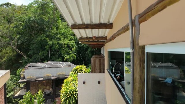 Drone rises from a balcony revealing a mud dauber wasp nest under the roof