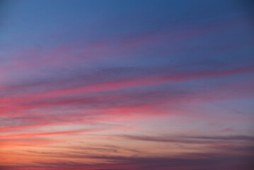 Obraz premium Pastel pink and purple sunset sky with soft cloud streaks