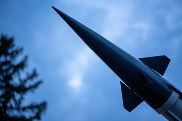Missile rocket silhouette against cloudy blue sky
