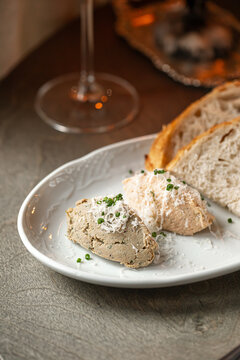Traditional French salmon and duck rillettes served with fresh bread and grated cheese on elegant plate