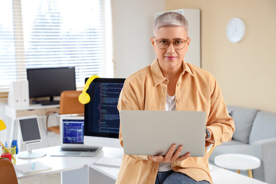 Female programmer working with laptop in office