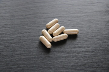 pills capsules medicine on a black background in large print,