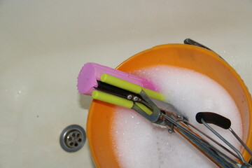 a pink mop with a sponge in a bucket of water,