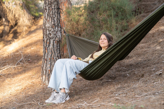 Young woman relaxing in hammock enjoying nature outdoors