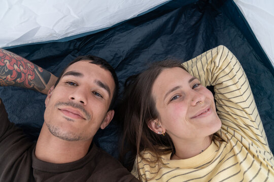 Couple relaxing together inside camping tent