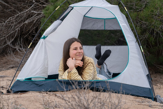 Young woman enjoying leisure time in camping tent