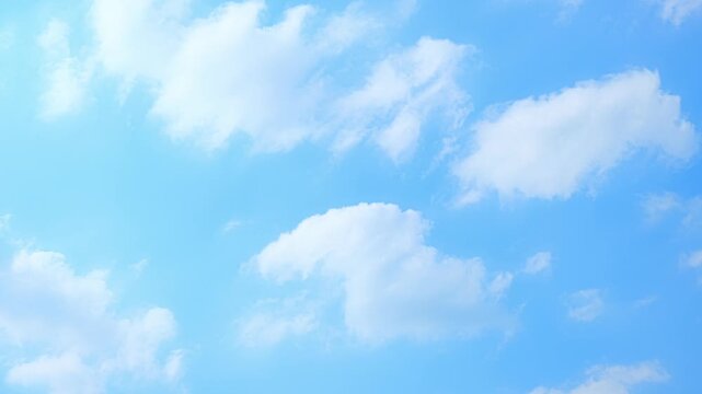 A blue sky timelapse video showing soft cumulus clouds drifting gently across a bright atmosphere, highlighting cloud types, motion, and natural sky patterns in a calm, airy scene.
