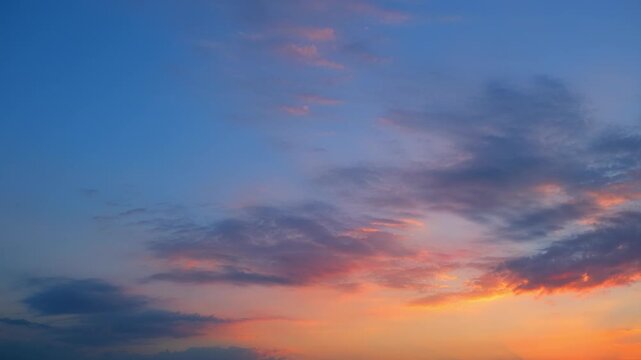 A sunset sky timelapse video featuring drifting stratocumulus and altocumulus clouds glowing in warm orange and gold light, revealing layered cloud types and dramatic evening atmosphere.
