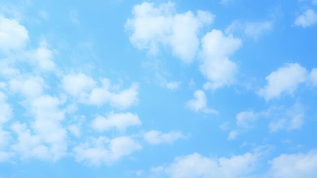Timelapse of a vivid blue sky with drifting cumulus clouds, soft white formations slowly evolving and gliding overhead, highlighting dynamic cloud types and natural atmospheric motion.
