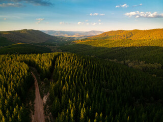 Drone aerial view of misty mountain farmland in New South Wales, Australia, showing rural agricultural paddocks, forested valleys and rolling highlands under low cloud and fog