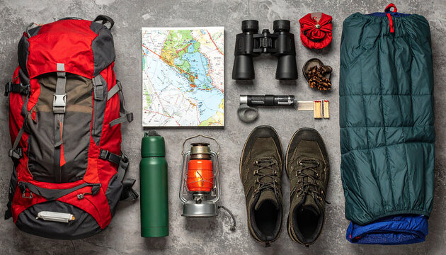 flat lay of camping gear  like a backpack  thermos  binoculars  sleeping back