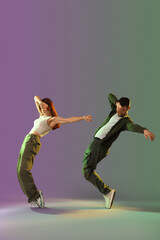 Naklejka premium Young couple of hip-hop dancers on dark background