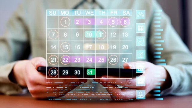 Person holds a smartphone while looking at a digital calendar with dates and other information displayed clearly on the screen.