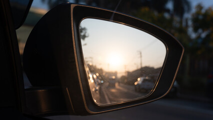 Fototapeta premium Mirror view of car black color. Inside glass can see traffic in the morning with clear road and sunrise.